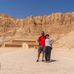 Couple posing in front of Hatshepsut Temple in the Valley of the Kings, Egypt, exploring the ancient wonders with Discovery Tours Egypt.