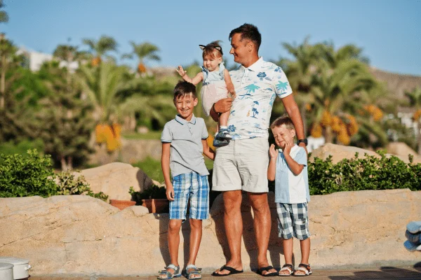 Family posing together in a sunny location in Egypt, with palm trees in the background.