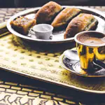 Samosas with chutney on ornate tray.